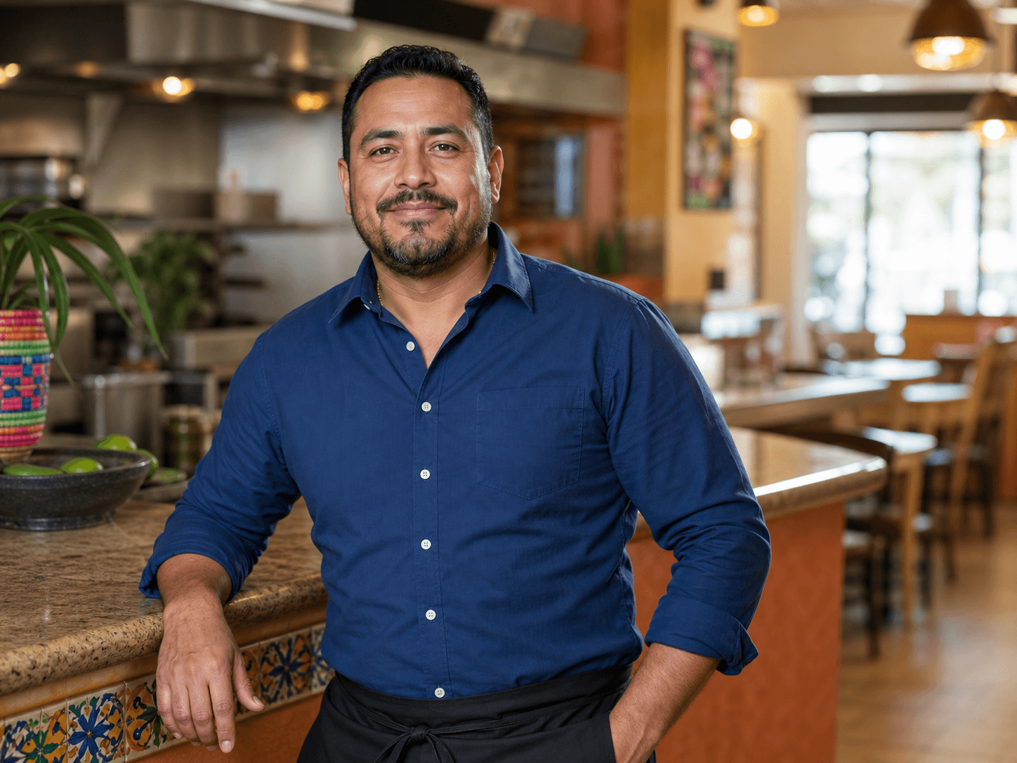Representative portrait of a taqueria and grill general manager inside his restaurant